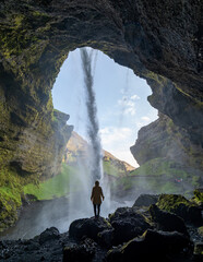 Majestic waterfall cascades through a cave in Iceland highlighting natures beauty