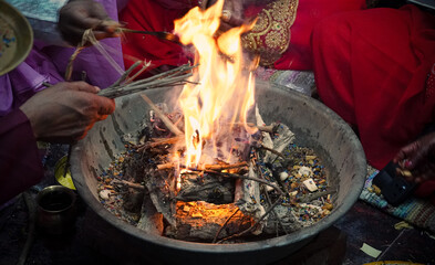 Holy fire (havan or yajna) during a Hindu religious ceremony, performed by devotees with offerings...