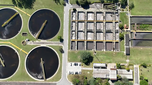 V&iacute;deo a&eacute;reo de esta&ccedil;&atilde;o de tratamento biol&oacute;gico de &aacute;guas residuais com tanques circulares em opera&ccedil;&atilde;o, ilustrando processos modernos de saneamento ambiental