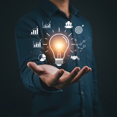 Man holding glowing light bulb with business and success icons floating around