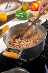 Cooking beans in a saucepan on the stove in the kitchen.