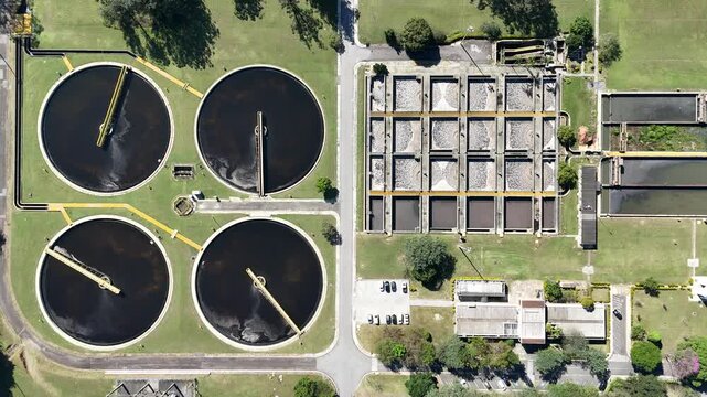 Vista a&eacute;rea de grande planta de tratamento de &aacute;gua com m&uacute;ltiplos tanques retangulares organizados, cercada por vegeta&ccedil;&atilde;o, mostrando efici&ecirc;ncia e integra&ccedil;&atilde;o ambiental