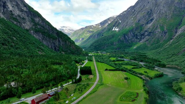 Aerial of the Rauma river winding through meadows and farmland in the Romsdalen Valley in Norway.