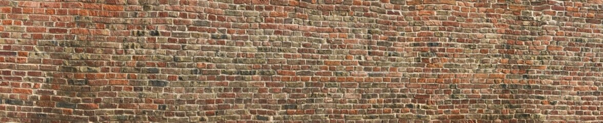 Panorama of a textured old brick wall surface in vivid earthy tones