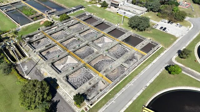  Top-down aerial view of activated sludge treatment basins in a sanitation industry facility, highlighting circular tanks and wastewater processing structures