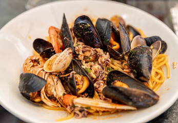 Traditional Italian dish - pasta with seafood close-up on a white plate