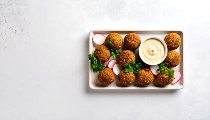 Middle Eastern Falafel Balls With Tahini Sauce Pickled Radish and Parsley on White Plate