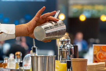 Bartender mixing orange cocktail with ice on a summer festival