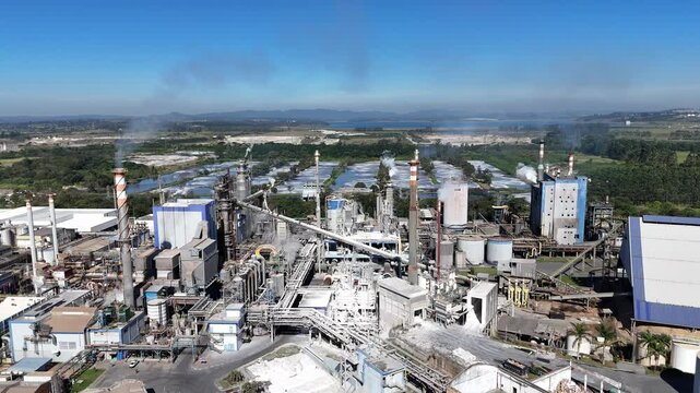 Vista frontal e lateral de uma ind&uacute;stria de papel e celulose mostrando caldeiras, tubula&ccedil;&otilde;es, m&aacute;quinas e a escala da produ&ccedil;&atilde;o industrial brasileira
