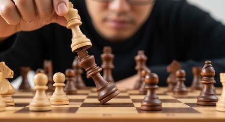 Close-up of a chess game in progress, with a king falling. Represents strategic thinking, competition, and decisive moves.