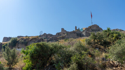 Ruins and fragments of walls of medieval Crusader castle, built in XV century by Knights Hospitaller of Order of St. John on hill above city of Fethiye, Turkey