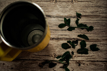 Fresh mint leaves are scattered organically across a textured wooden surface. This image highlights...