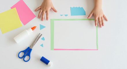 children's craft project with paper shapes and colorful materials. child's hands on white background surrounded by scissors, glue, and vibrant paper pieces for creative activity