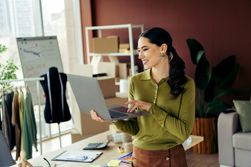 Busy entrepreneur working with a laptop in a stylish modern workspace, showcasing a fashionista's...