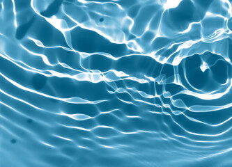 Abstract blurred shades of blue water background. Light and shadow ripples or splashes surface of water texture. Water waves with shining and reflection pattern photography for​ design artwork.
