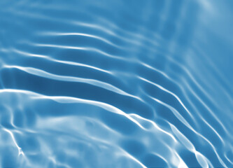 Abstract blurred shades of blue water background. Light and shadow ripples or splashes surface of water texture. Water waves with shining and reflection pattern photography for​ design artwork.