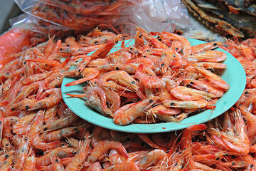 Camarones frescos sobre un plato de color verde.