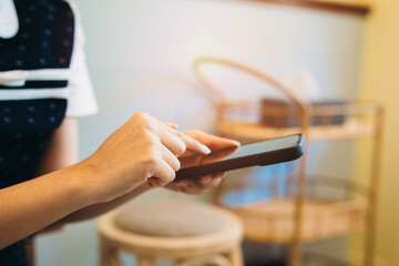 Woman using smartphone. Woman Using Smartphone in Cozy Café Setting with Natural Light and Modern Décor