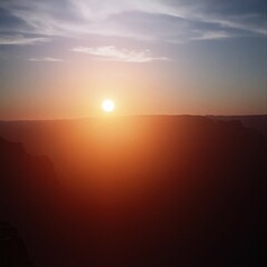 Fototapeta premium Majestic canyon at sunset illuminated in warm light with deep shadows evoking a cinematic feel in burnt orange tones