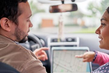 Couple traveling using gps navigation on tablet in car