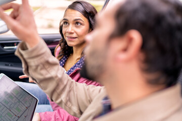 Couple traveling using gps navigation on tablet in car