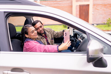 Happy couple taking a selfie while traveling by car