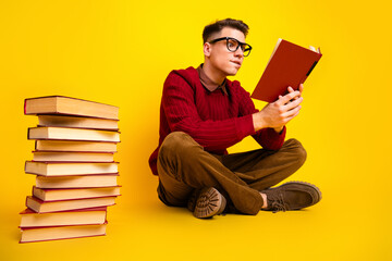 Intelligent student Young Handsome Man Reading a Book with a Vintage Look on Yellow Background