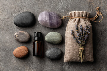 Aromatherapy set with stones, flowers and oil bottle on textured background