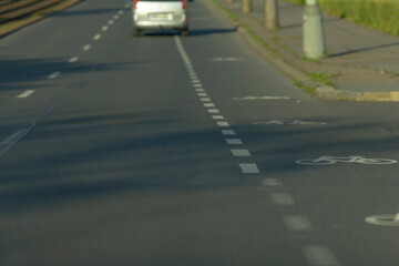 A white van is making its way down a street adjacent to a designated bicycle lane meant for cyclists to ensure their safety