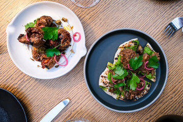 Romantic dinner for two. Two plates with starters or appetizers on a round wooden table.