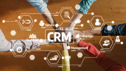 Collaborative Business Team Engaging in CRM Strategy with Hands Joining Over Digital Icons Representing Customer Relationship Management Concepts. Amity