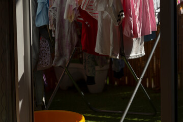 A bunch of colorful clothes are hanging on a rack placed outside in the open air, creating a...