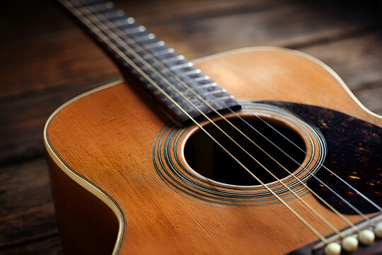 Acoustic guitar resting on wooden tabletop in warm light