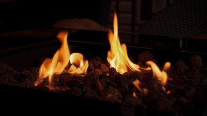 Warm Flames Dancing At Night In A Fire Pit With Lava Rocks for Cozy Outdoor Living.