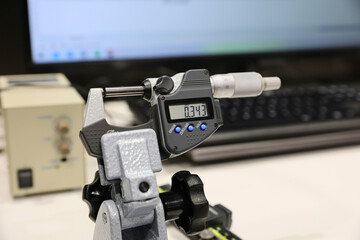 An electronic micrometer and several control and measuring instruments are on display at a trade fair for industrial tools and machinery.