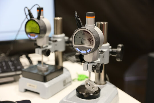 A comparator watch and several control and measuring instruments are on display at a trade fair for industrial tools and machinery.