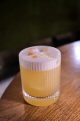 Pisco sour cocktail - whiskey with lime, egg white, sugar syrup in glass on grey table. Space for...