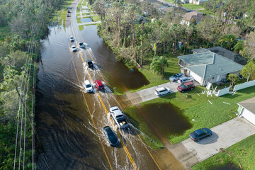 Aerial view of flooded street after hurricane rainfall with driving cars in Florida residential...