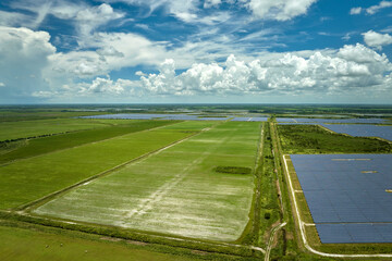 Aerial view of sustainable electrical power plant between agricultural farmlands with photovoltaic...