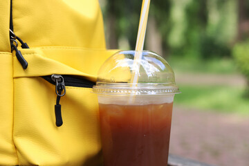 Coffee with juice in a disposable plastic cup with a straw. Coffee with orange juice, syrup and...