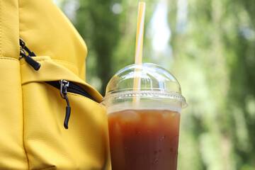 Coffee with juice in a disposable plastic cup with a straw. Coffee with orange juice, syrup and...