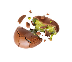Broken chocolate candy with green creamy filling isolated on white background. Dubai chocolate is made with pistachio paste and kadayif