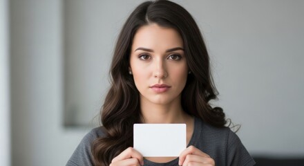 Beautiful woman holds blank card for message or promotion