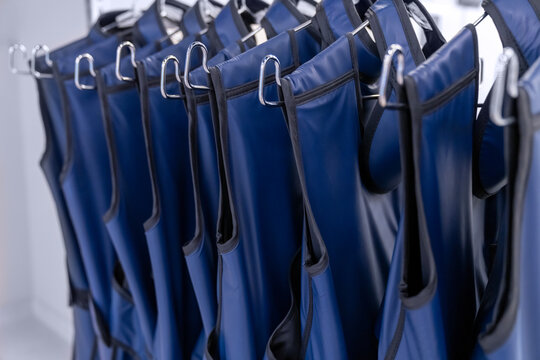 A rack of lead aprons used for protection from Xray, x-ray, x ray beam in operating room or dentist or radiologist, hospital. radiation protective vest.