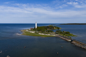 Arial view of a white lighthouse L&aring;nge Erik on the coast of &Ouml;land, Sweden surrounded by rugged shoreline, meadows and Baltic sea. 
