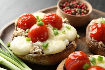 Tasty stuffed mushrooms served on black table, closeup