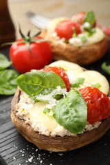 Tasty stuffed mushrooms served on wooden table, closeup