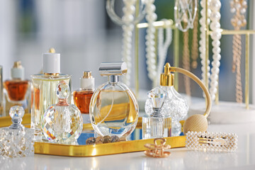 Bottles of different perfumes and accessories on table indoors