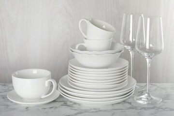 Different clean dishware on white marble table indoors
