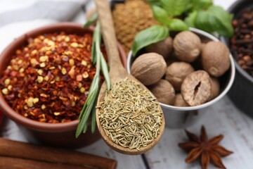 Different aromatic spices on white wooden table, closeup